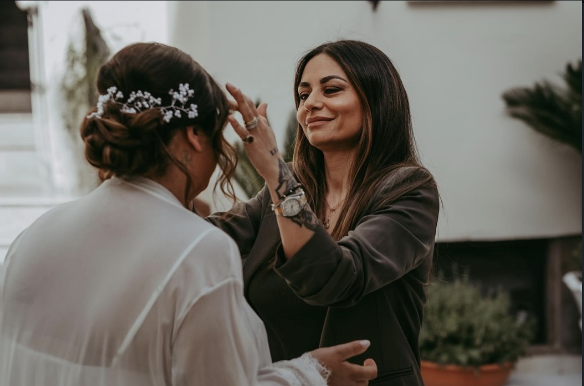 Giovanna mentre cura gli ultimi dettagli dell'acconciatura di una sposa